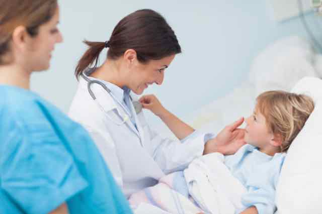 médica olhando para paciente criança