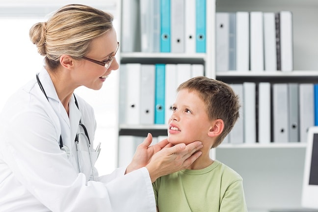 médica examinando uma criança com caxumba