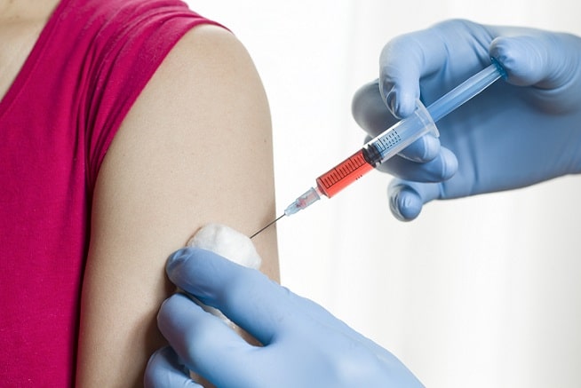 enfermeira vacinando uma mulher contra a influenza