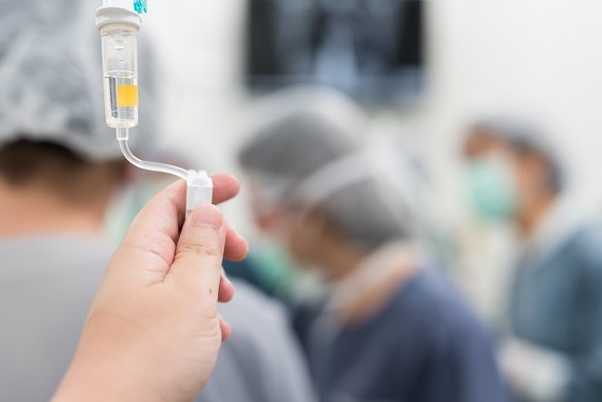 mão de enfermeiro realizando infusão de medicamento em paciente com coronavírus