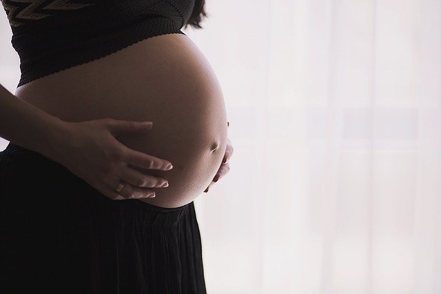 Mulher grávida pensa se deve se deslocar até uma unidade de atendimento primário de saúde durante a pandemia de Covid-19