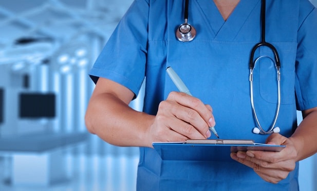 médico anotando em prancheta sobre cuidados de terapia intensiva na covid-19