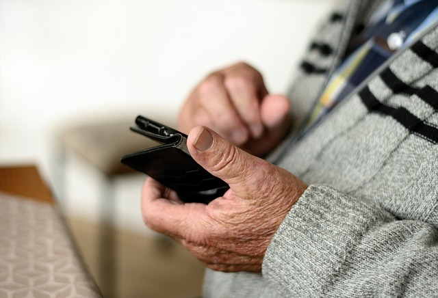 idoso usando celular para fazer avaliação geriátrica via telemedicina