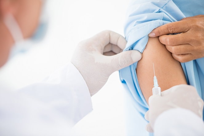 médico aplicando vacina contra covid-19, coronavac, em paciente