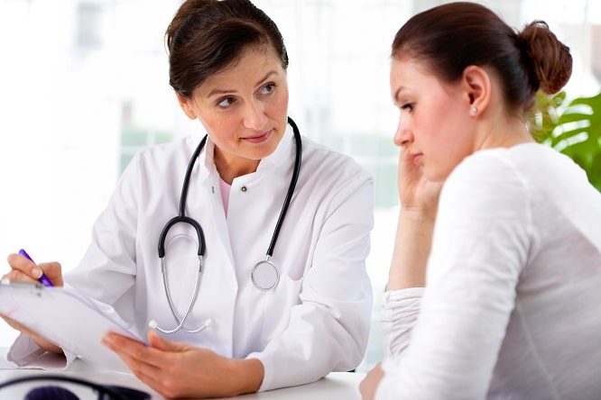 médica conversando com paciente com efeitos tardios do câncer infantil