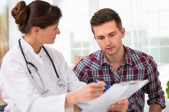 Médica dá orientações ao paciente após consultar categoria do Whitebook