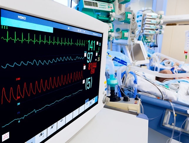 monitor de UTI e paciente ao fundo com disfunção hematológica pediátrica