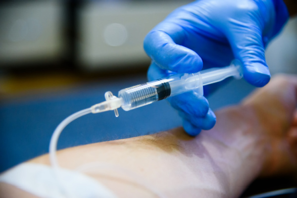 mão de médico injetando noradrenalina
