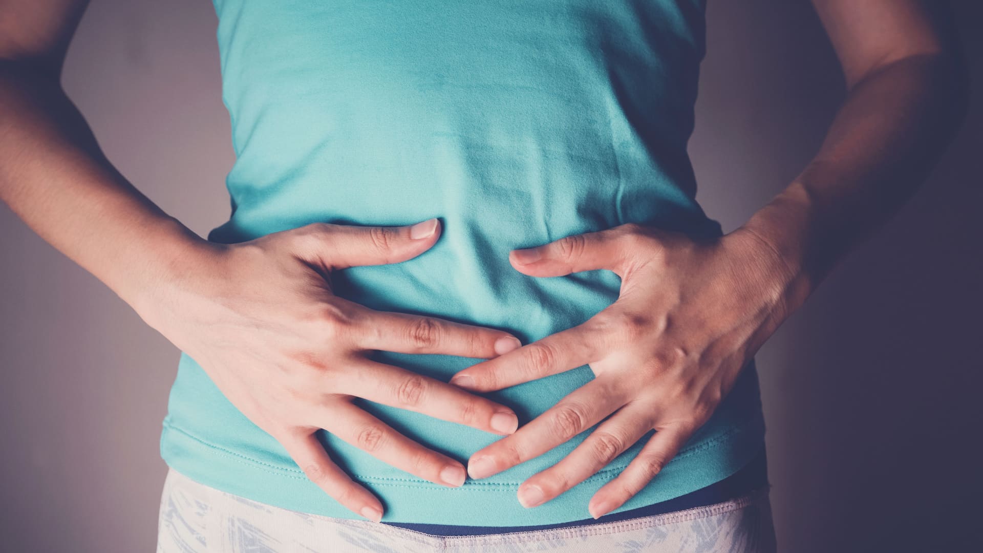 Mullher com Leaky Gut Syndrome com as mãos apoiadas sobre a barriga