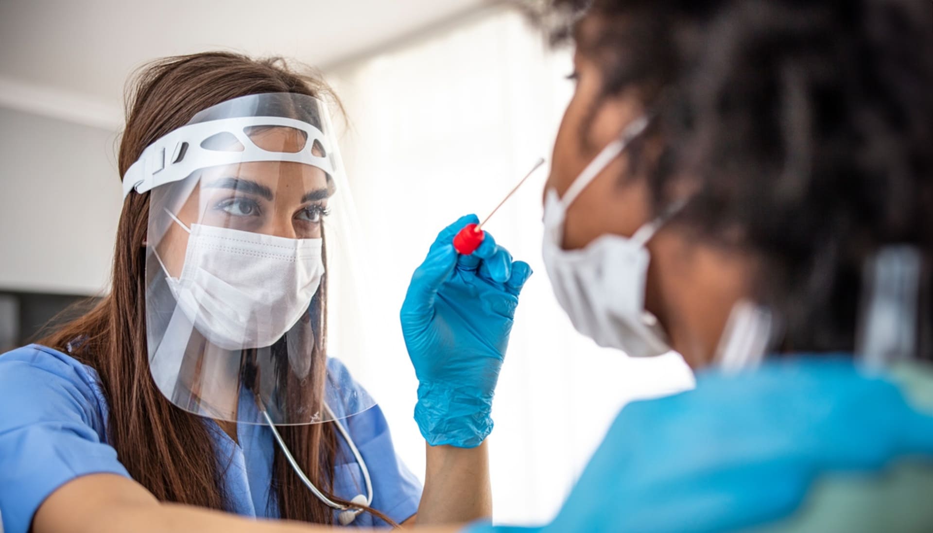 Profissional de saúde realizando teste de covid-19 em paciente