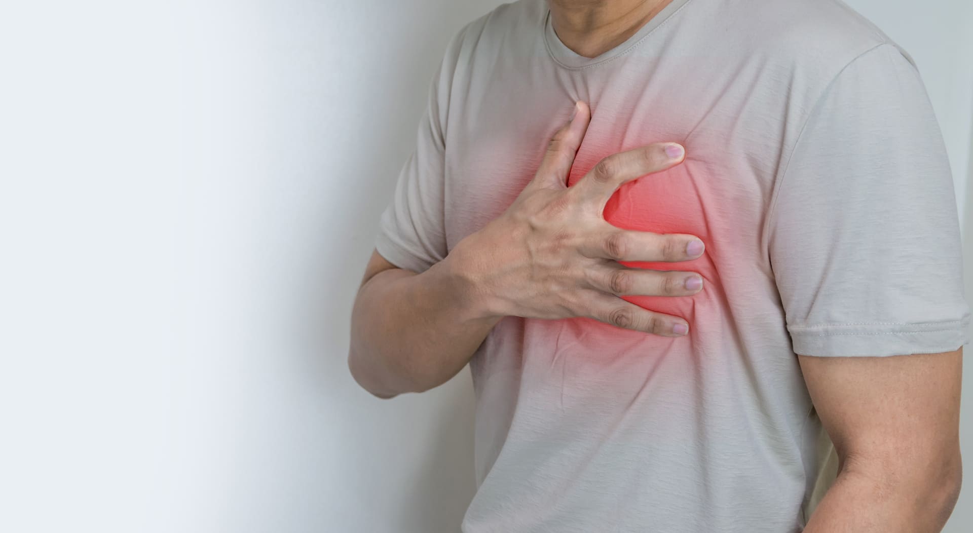 Homem com princípio de infarto levando a mão ao peito.