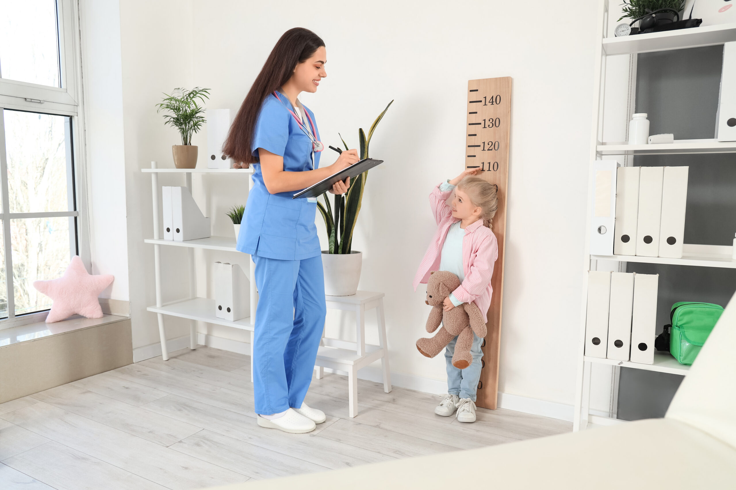 pediatra medindo altura criança