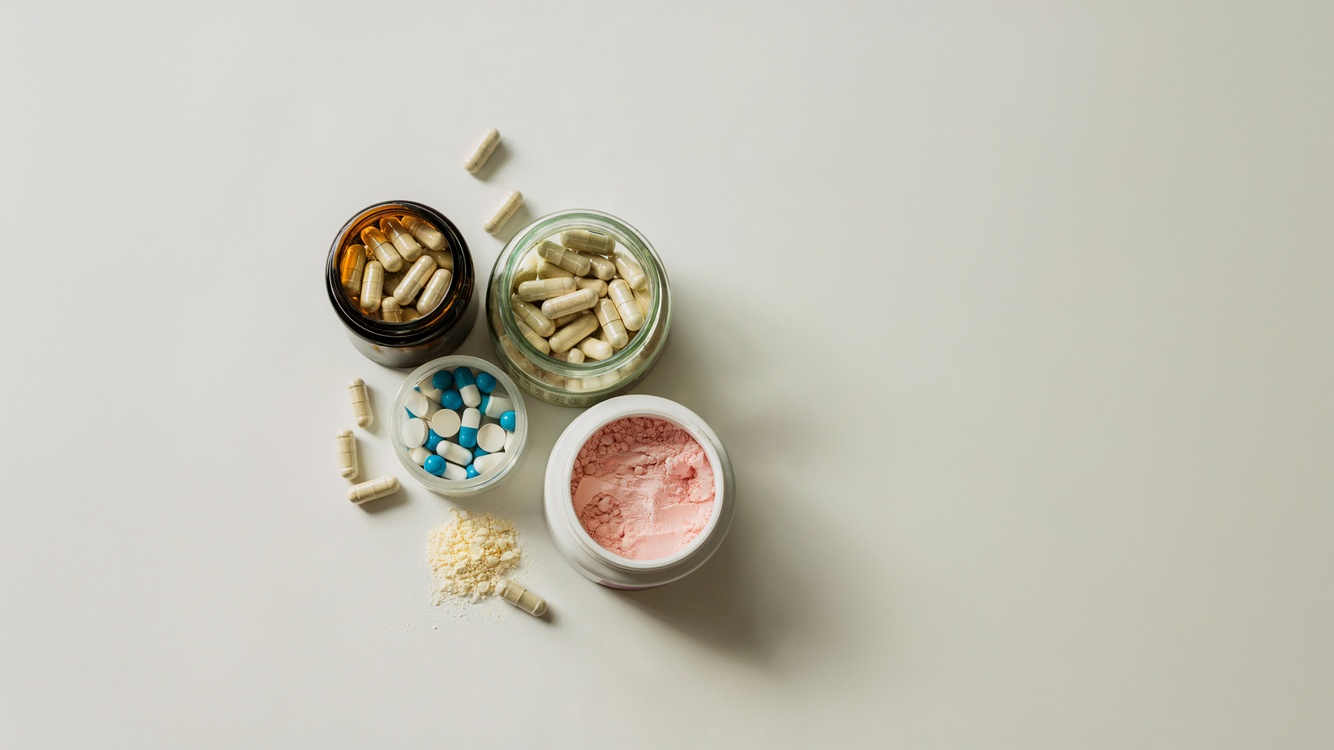 Suplementos diversos, em pó e cápsula, sobre uma mesa